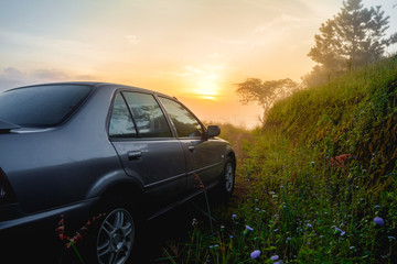 Obraz na płótnie Canvas Travel concept car against sunrise and trail on mountains. Close Up photo of off-road wheel