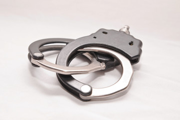 A set of black and white handcuffs isolated on  a white background