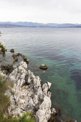 background image of rocky seashore on different Islands of Greece, Rhodes, KOs, Santorini, Halkidiki, Crete, Simi, Corfu