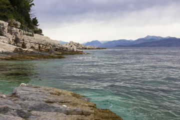 background image of rocky seashore on different Islands of Greece, Rhodes, KOs, Santorini,...