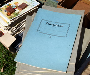 Stapel mit alten Schreibheften (Schulheften) auf einem Flohmarkt