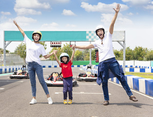 happy family standing on the go kart race track - obrazy, fototapety, plakaty