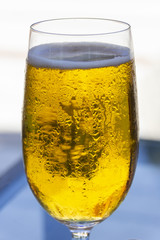 a glass of cold beer with bubbles, different nuts, hot summer day on an outdoor terrace in a bar by the sea