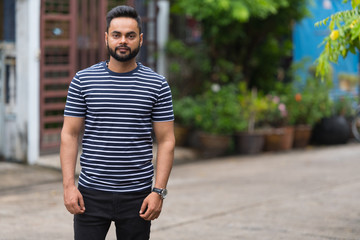 Fototapeta premium Young bearded Indian man in the streets outdoors