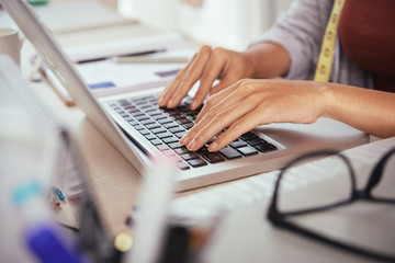 Hands of tailor posting photos of her work online