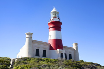 Fototapeta na wymiar Lighthouse on Cape Agulhas in South Africa on blue sky background, close up