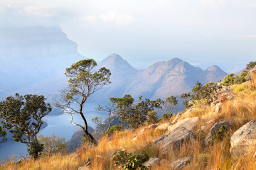 Blyde River Canyon, three trees, blue lake and mountains in the clouds in sunset light background,...