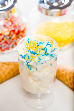 Close-up of a glass with cream ice cream and decorative sprinkle