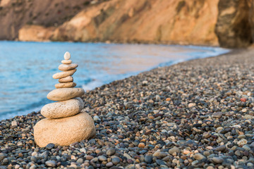 Fototapeta na wymiar close-up of a pyramid of white stones on a pebble beach concept photo balance