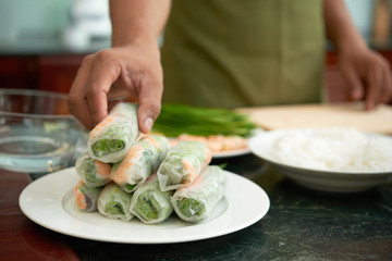 Man cooking bunch of spring rolls for dinner