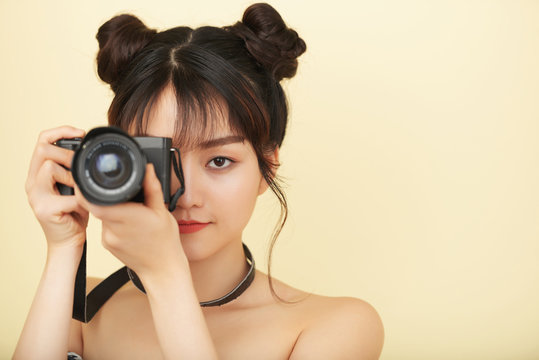 Beautiful creative young woman taking photos with digital camera