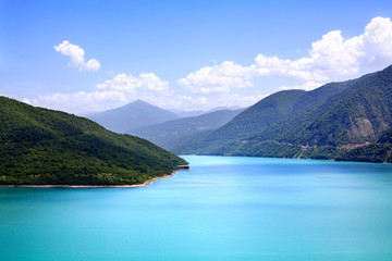 Naklejka na ściany i meble Azure water in a blue sea lagoon among green mountains blue sky white clouds background, paradise on earth, nobody