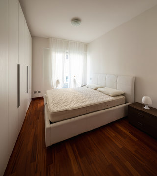Bedroom with large wardrobe and bright window