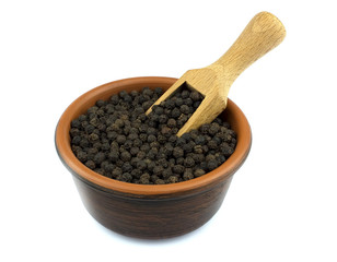 Black pepper in the bowl isolated on white background with a woo