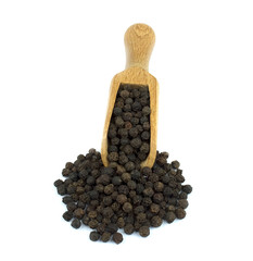 Black pepper on wooden scoop isolated on white background