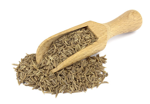 Cumin seed on wooden scoop isolated on white background