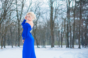 Fototapeta na wymiar Winter holiday concept. Inspiration and fairy cold time. Woman in fashionable evening dress at park . Pretty nice lady outdoor, holiday days, snowy magical christmas time 