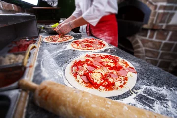 Foto op Aluminium Cooking pizza in cafe. A dough for a pizza in the hands of the chef. © serkucher