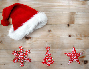 Obraz na płótnie Canvas red santa hat with christmas decoration on plank