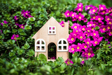 Naklejka premium The symbol of the house stands among the flowers of the Primrose 