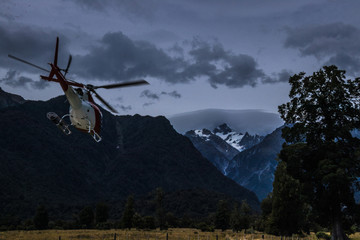 Fototapeta na wymiar Flying helicopter against powerful mountains