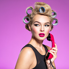 Girl wears curlers in hair with a  looking sad.