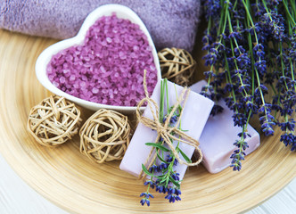 Heart-shaped bowl with sea salt, soap and fresh lavender flowers
