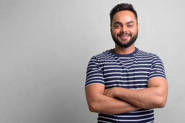Young bearded Indian man against white background