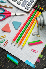 Bright stationery on an open notebook. school background