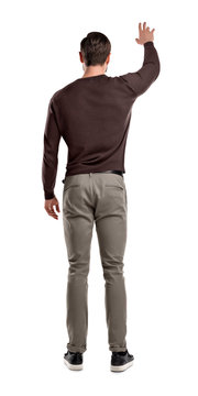 A Fit Man In Casual Sweater Stands In A Back View With One Arm Lifted Up To Attract Attention To Him.