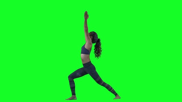 amazing female yoga instructor moving between poses against chroma green sceeen