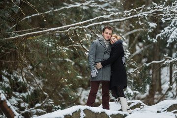 Winter outdoor fashion portrait of young sensual couple in forest