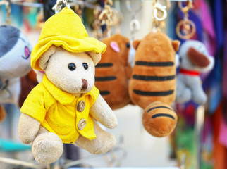 A small teddy bear in a yellow jacket and hat.