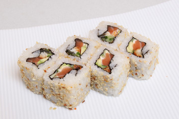 Roll California in sesame. Sushi with crab, eel, cucumber. Japanese food on a beautiful dish.