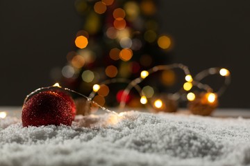Christmas balls with an electric garland under the snow