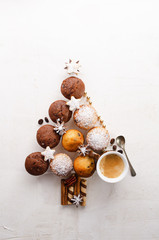 Assorted muffins in the shape of a Christmas tree with cup of coffee espresso on the white textured background. Top view.
