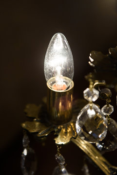 A romantic candle-like Light bulb is lit in a dark room. Vintage electric lighting in the room. 