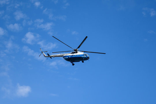 Russian helicopter flying high in the sky. Air transport on the background of clouds. 