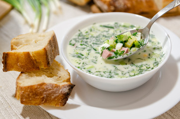 Traditional Cold Soup Okroshka with cucumber, sausage, potatoes, eggs, greens and sour cream.