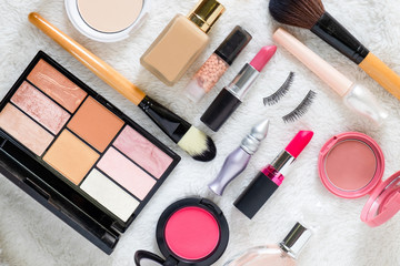 Flat lay of beauty cosmetic products and Various Make up accessories on the white fur background with copy space for your text. Concept of Beauty Knolling.