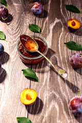 Plums and jam of plum on wood background