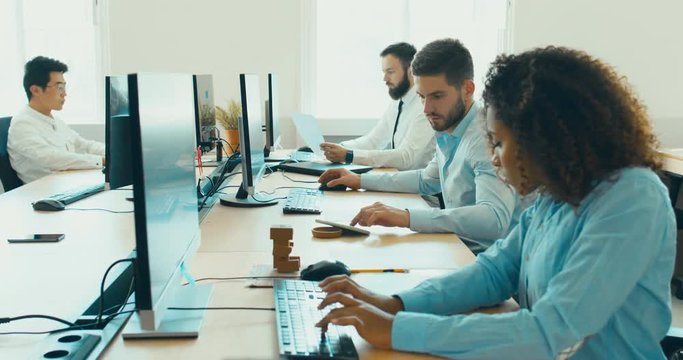 Multi racial team of employees working in a modern office. 4K UHD 60 FPS SLOW MOTION