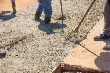 Worker work on concrete with rake,cement in building site,pouring cement during upgrade to...