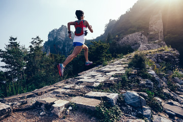 Sporty fitness woman runner running on mountain top