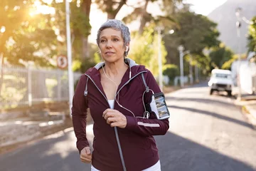 Selbstklebende Fototapete Joggen Ältere Frau, die auf der Straße joggt