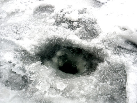 The scrounged hole in the frozen lake. Winter fishing
