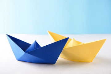 Origami boats on white table