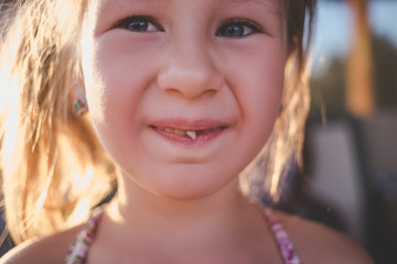 Fototapeta premium Portrait of a little girl with an outstretched milk tooth