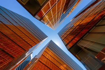 Goldenes Gebäude mit blauem Himmel. Windows-Glas moderner Bürowolkenkratzer. Fassadengestaltung. Architektur außen für Stadtbildhintergrund. © tampatra