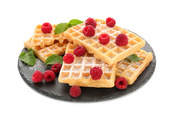 Slate plate with delicious waffles and raspberries on white background